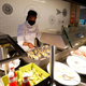 a masked worker at a buffet